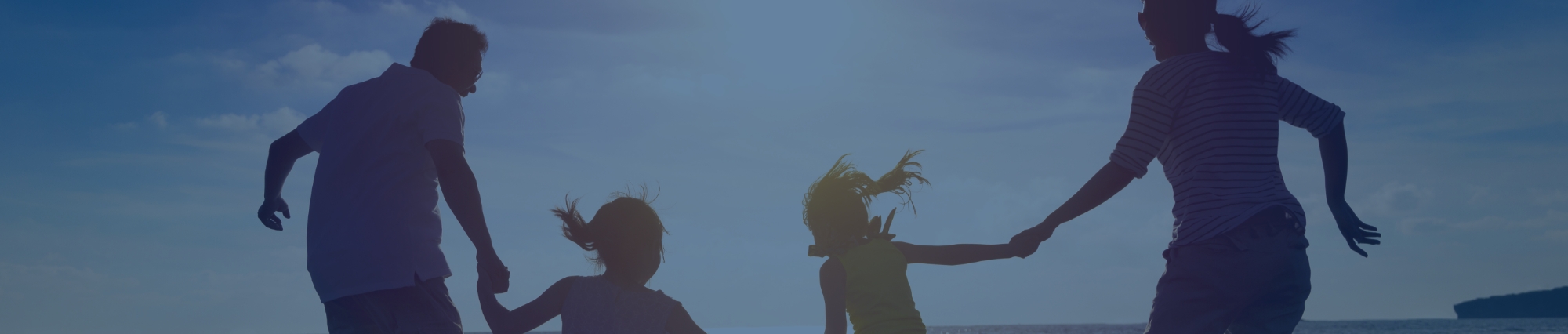 Happy family jumping together on the beach